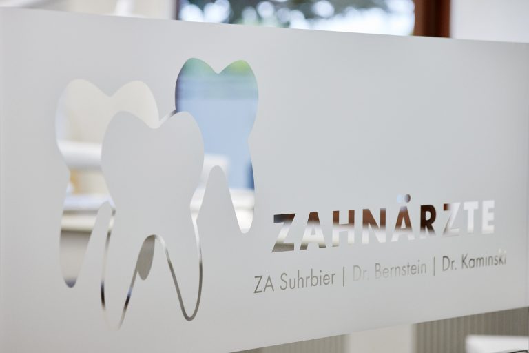 Logo der Zahnarztpraxis SBK an einer Glaswand